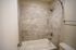Elegant bathroom with soothing beige tiles and a modern full-size bathtub, offering a serene retreat.