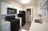 Modern kitchen with sleek white cabinetry, black appliances, and elegant countertops, offering functional and stylish appeal.