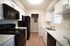 Modern kitchen with sleek black appliances and elegant white cabinetry, featuring ample countertop space and natural light.