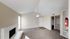 Inviting apartment interior featuring a cozy fireplace, plush carpeting, and an elegant ceiling fan.