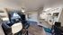 Inviting living room with elegant decor, cozy couches, and vibrant curtains, seamlessly flowing into a modern, well-equipped kitchen.