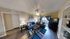 Elegant living room with modern decor, featuring plush sofas, a stylish coffee table, vibrant area rug, and a large flat-screen TV, accented by natural light from the balcony.