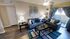 Inviting living room with plush gray sofas, decorative pillows, and stylish lamps, opening onto a cozy balcony through elegant drapes.