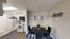 Charming dining area with modern white kitchen, featuring sleek appliances and whimsical decor for a cozy atmosphere.