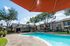Inviting apartment complex with a sparkling outdoor pool, surrounded by lush greenery and comfortable lounge areas.