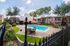 Charming apartment complex with a pristine outdoor pool, cozy seating, vibrant greenery, and inviting umbrellas, perfect for relaxation and socializing.