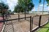 Inviting fenced outdoor area with lush green trees and a sunny sky, perfect for recreational activities.