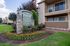 Inviting entrance of Parkside Apartment Homes surrounded by lush landscaping and vibrant floral arrangements.