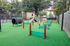 Charming outdoor pet agility park with vibrant red and green obstacles, providing a fun and engaging play area for pets in a community setting.