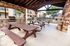 Charming covered patio area with rustic wood benches and stone grill, ideal for outdoor gatherings and relaxation.