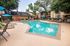Inviting pool area with lush surroundings and comfortable lounge chairs in a serene apartment community.