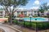 Charming apartment complex featuring a lush green courtyard and inviting swimming pool, perfect for relaxation and leisure.