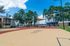Inviting outdoor recreational area with a vibrant play court, shaded seating, and lush greenery, perfect for leisure activities.