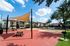 Spacious apartment community with a sun-shaded outdoor area, picnic tables, and a pool with umbrella-covered seating.