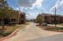 Inviting apartment complex with charming brick buildings and well-maintained landscaping under a bright blue sky.