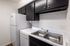 Modern kitchen space with sleek stainless steel double sink, elegant black cabinetry, and stylish marble-patterned countertop.