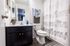 Charming bathroom with elegant elephant-themed shower curtain, modern vanity, and warm wooden flooring.