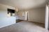 Spacious and inviting living area with carpeted floor, open kitchen bar, and ample natural light, perfect for relaxation and entertaining.