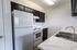 Modern kitchen with sleek black cabinetry, pristine white countertops, and a contemporary double sink.