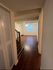 Inviting apartment hallway with elegant wooden flooring and a bright, open living space.
