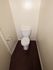 Contemporary bathroom with a sleek toilet and elegant dark flooring, offering a clean and minimalist design.