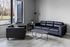 Modern apartment living room with sleek black leather sofas, a stylish coffee table, and airy natural lighting from large windows.