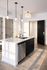 Elegant kitchen featuring a sleek marble island with modern pendant lighting and stainless steel appliances, creating a sophisticated ambiance.