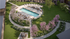 Inviting outdoor space with a pristine swimming pool, surrounded by elegant lounge chairs and blooming pink trees, creating a serene oasis.