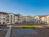 Charming apartment complex featuring modern three-story buildings with balconies and a spacious courtyard, perfect for enjoying outdoor activities.