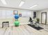 Bright and inviting fitness room featuring modern exercise equipment, including a stationary bike, yoga balls, and sleek free weights, perfect for a convenient workout at home.