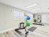 Bright and inviting residential gym with modern equipment, exercise balls, stationary bike, and natural light.
