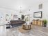 Inviting living room with modern gray sofa and chic lighting, featuring stylish wood flooring and contemporary decor.