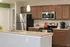 Modern kitchen with sleek granite countertops, stainless steel appliances, and warm wooden cabinetry for a stylish culinary experience.