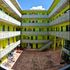 Community courtyard with colorful murals, a clear blue sky, and ample outdoor space.