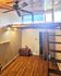 Charming loft-style room with wooden floors, ceiling fan, and rustic ladder access to upper level, ideal for creative living.
