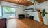 Charming room with a loft bed, cozy seating, and a sliding door leading to a private balcony with lush green views.