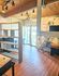 Charming loft-style room with a cozy workspace, large windows for bright natural light, and stylish wood accents.