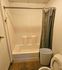 Modern bathroom featuring a clean white bathtub with a patterned shower curtain, perfect for stylish living.