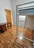 Contemporary bedroom with space-saving loft bed, sleek desk, and elegant hardwood flooring.