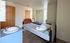 Cozy bedroom featuring a comfortable bed, natural light from large window, and sleek wooden accents.