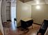 Cozy room featuring a workspace with a desk and chair, and an inviting atmosphere with natural light from a large window with blinds.