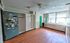 Spacious room with modern wood flooring, ample natural light from large windows, and versatile storage options.