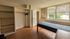 Bright bedroom with large window, built-in shelving, and convenient en-suite bathroom, offering natural light and ample storage.