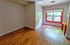 Bright room with large window, wooden flooring, and vibrant red accents, perfect for a creative workspace or cozy retreat.