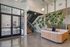 Modern lobby area with sleek design features, showcasing a green vertical plant wall, stylish seating, and an inviting staircase.