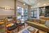 Modern, inviting living space with stylish seating areas, vibrant cushions, and abundant natural light through large windows.