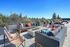 Vibrant rooftop terrace featuring modern outdoor seating, lush greenery, and panoramic forest views.