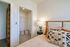 Cozy bedroom with elegant decor, featuring a plush bed, designer pillows, soft lighting, and a spacious walk-in closet.