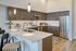Modern kitchen with sleek cabinetry, stainless steel appliances, and chic bar seating in a bright, open space.
