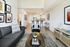 Contemporary open-plan living area with sleek kitchen and stylish decor, featuring modern furnishings and warm wood flooring.